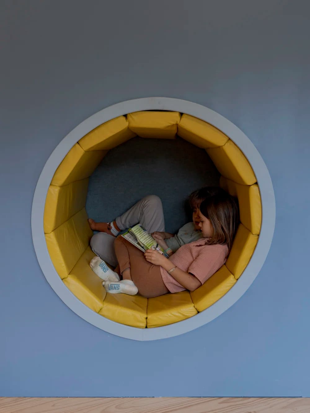 Early Years - A child reading in a cozy circular reading nook
