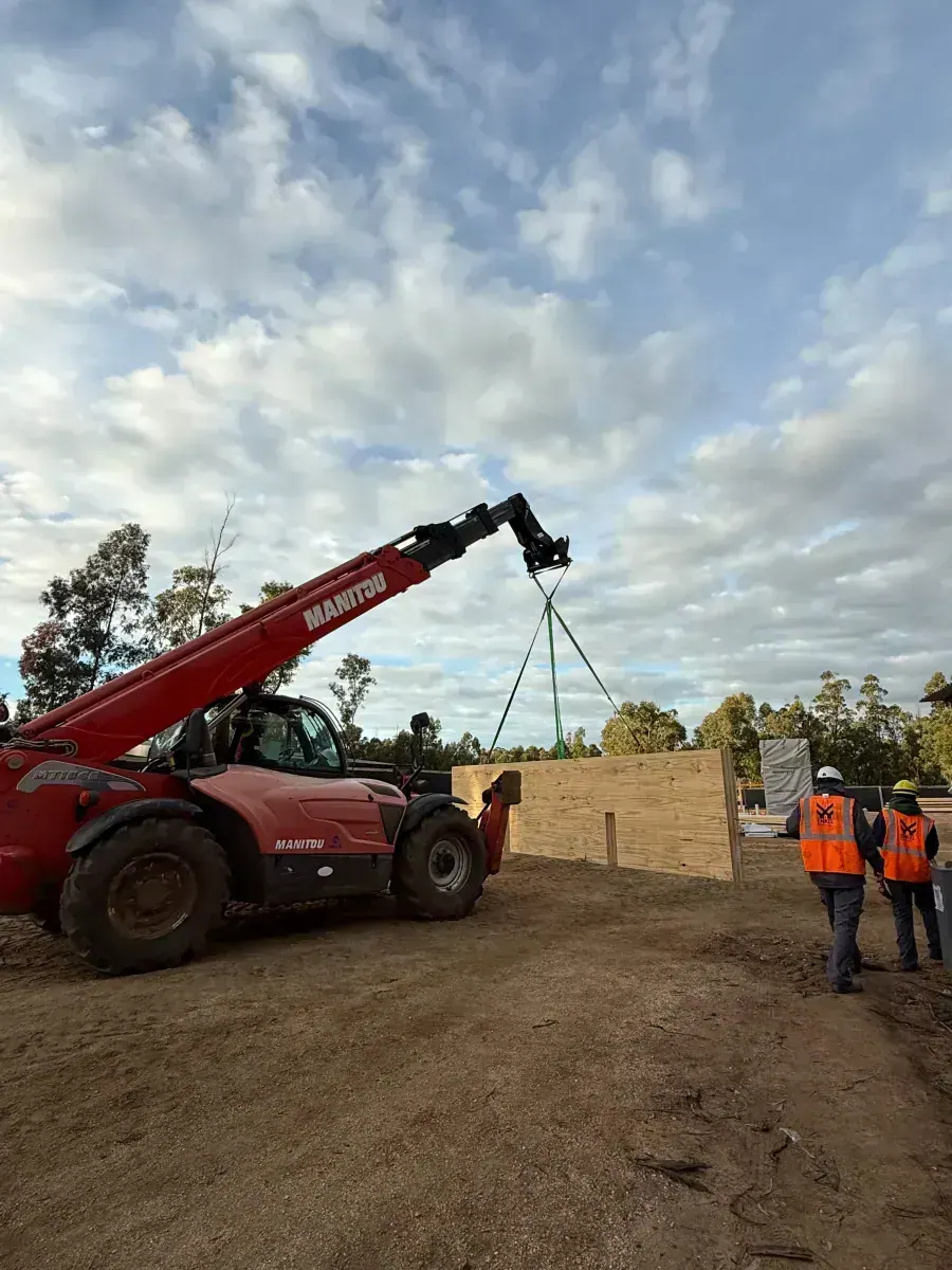 Telehandler lifting a wall panel into position