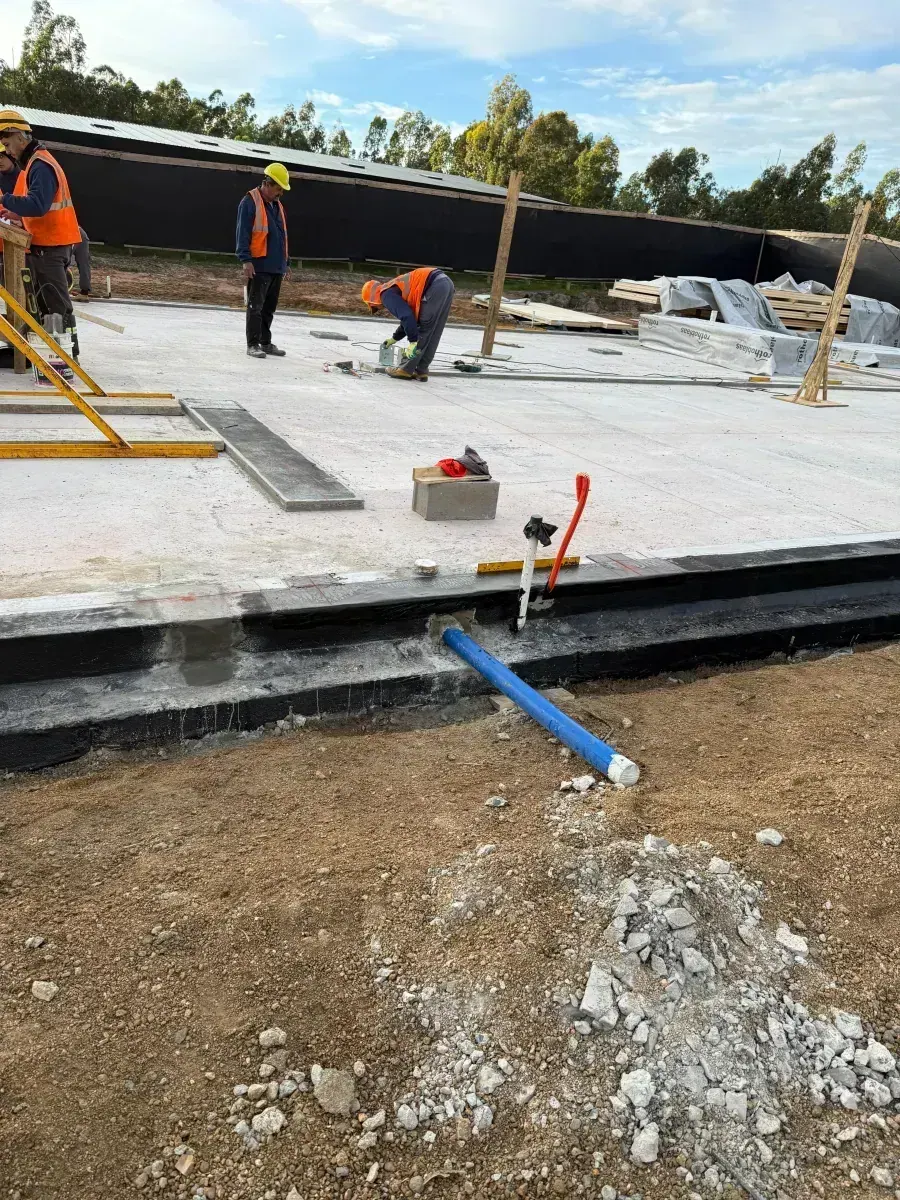 Workers finishing plumbing on the slab
